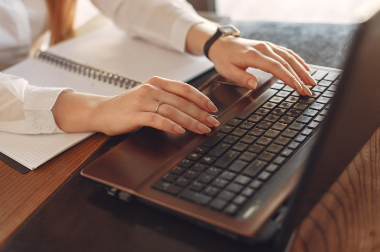 Person typing publications on a laptop.