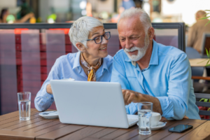 Older couple sitting behind a laptop