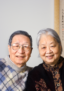 Older Asian Couple Smiling towards the Camera.